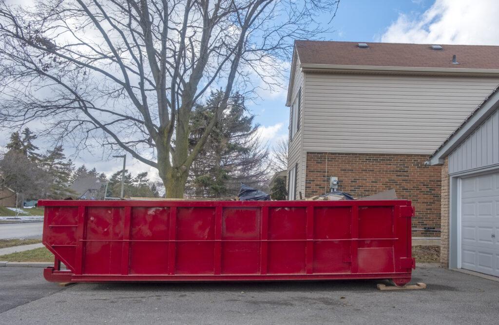 Red Dumpster Bin on a Driveway